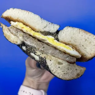 a hand holding a half eaten sandwich