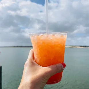 a hand holding a drink with a straw