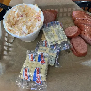 Slightly eaten sausage and pimento cheese and crackers