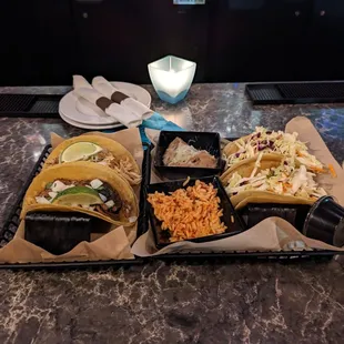 three tacos on trays on a table