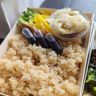 a plate of rice, broccoli, and other foods