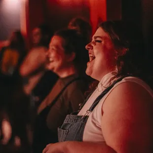 Some funny people watching other funny people up on stage.