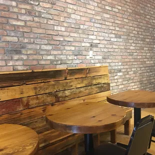 a table and chairs in front of a brick wall