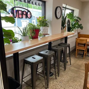 a row of bar stools in front of a window