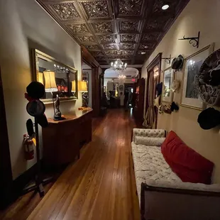 a long hallway with a couch and a chandelier