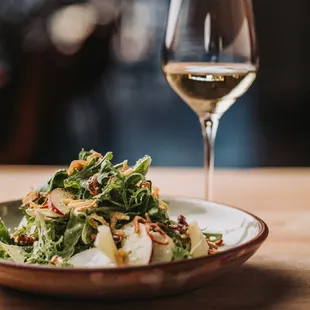 a plate of salad and a glass of wine