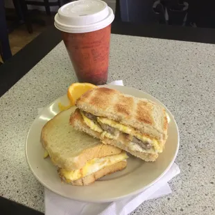 Custom breakfast panini-egg, sausage, caramelized onions, provolone cheese, garlic aioli on sourdough