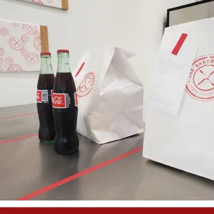 two bottles of coke and a paper bag