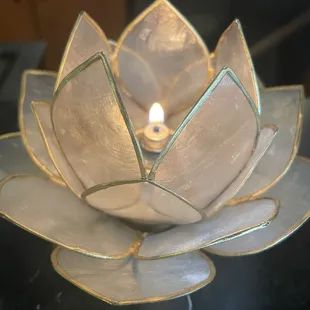 a candle in a glass lotus