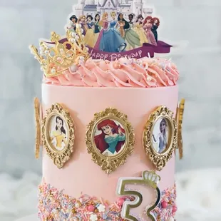 a cake decorated with disney princess decorations