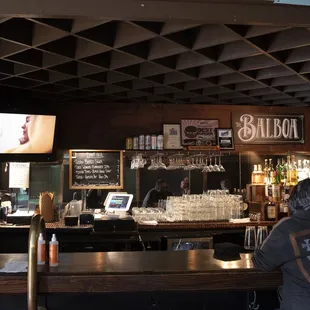 a bar with a man sitting at the bar