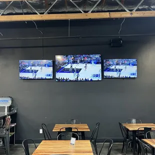 a restaurant with tables and televisions