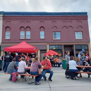 a large group of people sitting at picnic tables