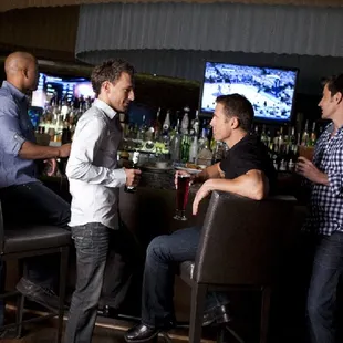 a group of men sitting at a bar