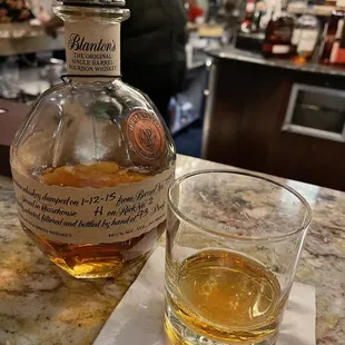 a bottle of bourbon next to a glass of whiskey