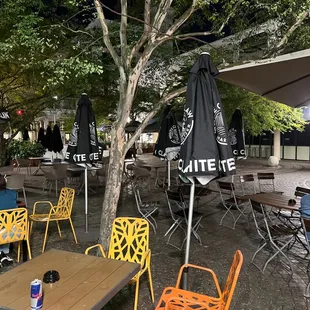 tables and chairs under a tree