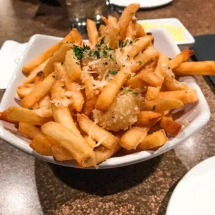 a bowl of french fries with parmesan cheese