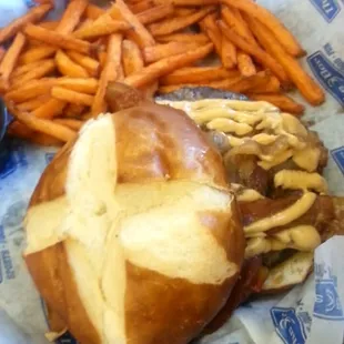 Pub burger with sauteed peppers, onion, bacon, and chipotle mayo on a pretzel bun