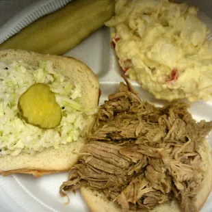 a pulled pork sandwich with cole slaw and pickle