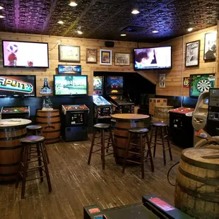 a bar with beer barrels and video games