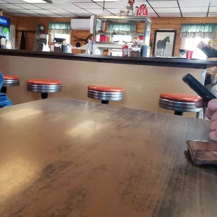 a person sitting at a table in a diner