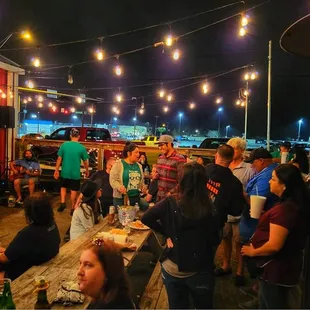 a large group of people eating outside at night