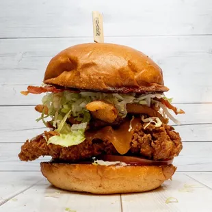 Western Chicken Stack: Brioche Bun, Choice of Chicken, Bacon, Cheddar,  BBQ Sauce, Onion Ring, Onions, Pickles, Lettuce