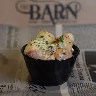 a bowl of potato salad on a newspaper