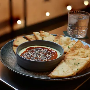 a bowl of dip and pita bread