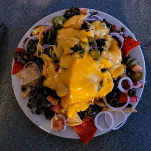 Nachos ($10.00). Ground beef, onions, black olives, jalapenos and nacho cheese.  Hands down the best bar nachos we&apos;ve ever had.