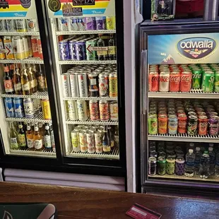 two refrigerators with drinks in them
