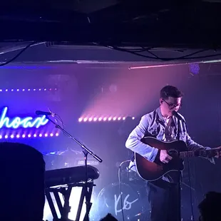 a man playing a guitar on stage