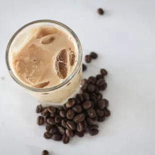 a glass of coffee and coffee beans
