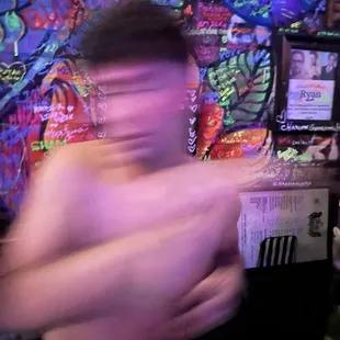 a shirtless man in a bar