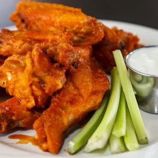 a plate of chicken wings and celery