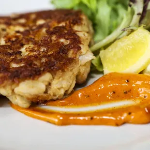 a crab cake with a side of salad