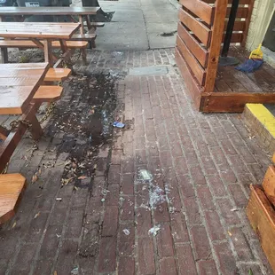 a row of wooden benches on a brick sidewalk