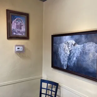 a blue chair in front of a painting