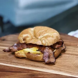 a croissant sandwich with bacon and eggs