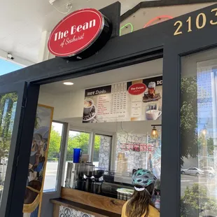 a woman standing in front of a coffee shop