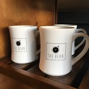two coffee mugs on a shelf