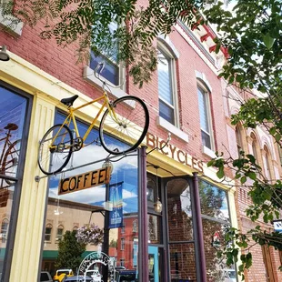 a bicycle hanging from the side of a building