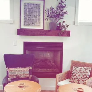 two chairs and a table in front of a fireplace