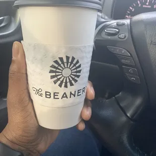 a hand holding a cup of coffee