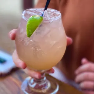a drink with a lime garnish