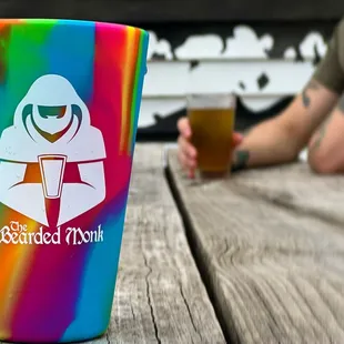 a rainbow colored cup on a wooden table