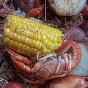 a pile of crawfish, corn and potatoes