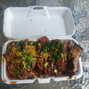 a styrofoam container with meat and cheese