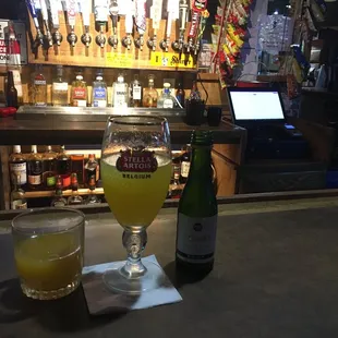 a bottle of beer and a glass of orange juice