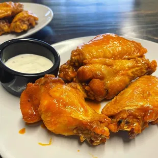 a plate of chicken wings with dipping sauce